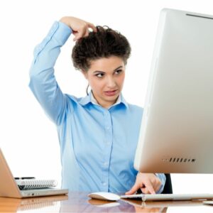 Woman starting at computer screen and scratching her head